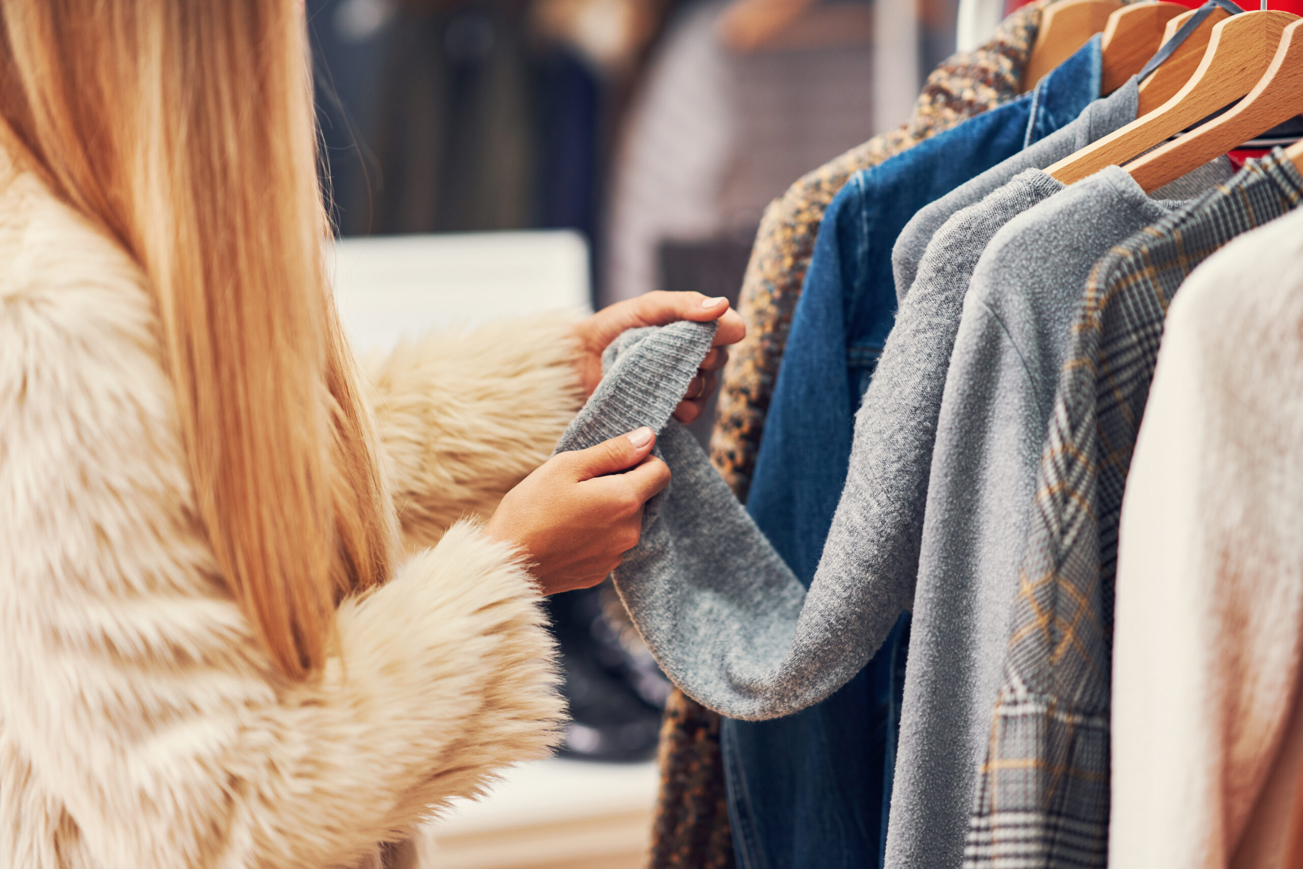 Happy adult woman shopping for clothes in boutique